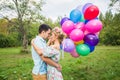 Summer holidays, celebration and dating concept - couple with colorful balloons in nature Royalty Free Stock Photo
