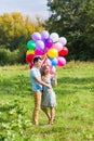 Summer holidays, celebration and dating concept - couple with colorful balloons in nature Royalty Free Stock Photo