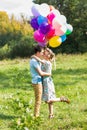 Summer holidays, celebration and dating concept - couple with colorful balloons in nature Royalty Free Stock Photo