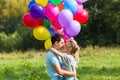 Summer holidays, celebration and dating concept - couple with colorful balloons in nature Royalty Free Stock Photo