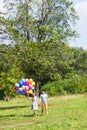 Summer holidays, celebration and dating concept - couple with colorful balloons in nature Royalty Free Stock Photo