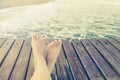 Summer holidays concept background with legs over wooden pier Royalty Free Stock Photo