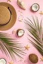 Summer holidays concept. Top vertical view photo of sunhat cracked coconuts shell bracelet earrings starfishes and palm leaves on Royalty Free Stock Photo