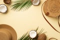 Summer holidays concept. Top view photo of hat round rattan bag cracked coconuts and green palm leaves on isolated beige Royalty Free Stock Photo