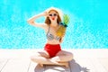 summer holidays concept - woman with pineapple having fun over a blue water pool Royalty Free Stock Photo