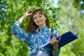 Summer holidays, education, campus and teenage concept - smiling female student with folders