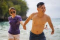 Summer holidays lifestyle portrait of young beautiful and sweet Asian Chinese couple in love running on the beach together Royalty Free Stock Photo