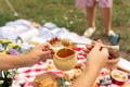 Summer holidays outdoor picnic. Woman hold the wooden honey spoon, honey drips from it to pot. Instagram content Royalty Free Stock Photo