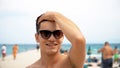 happy smiling handsome young man in sunglasses on beach Royalty Free Stock Photo