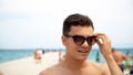 happy smiling handsome young man in sunglasses on beach Royalty Free Stock Photo