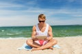 Happy smiling young man with tablet pc on beach Royalty Free Stock Photo