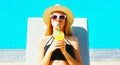 portrait woman drinking juice on deckchair over blue water pool background Royalty Free Stock Photo