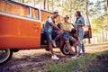 Summer holidays, road trip, vacation, travel and people concept - smiling young hippie friends having fun over minivan Royalty Free Stock Photo