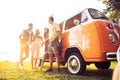 Summer holidays, road trip, vacation, travel and people concept - smiling young hippie friends having fun over minivan Royalty Free Stock Photo