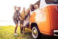 Summer holidays, road trip, vacation, travel and people concept - smiling young hippie friends having fun over minivan Royalty Free Stock Photo