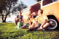 Summer holidays, road trip, vacation, travel and people concept - smiling young hippie friends having fun over minivan Royalty Free Stock Photo