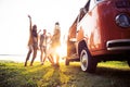 Summer holidays, road trip, vacation, travel and people concept - smiling young hippie friends having fun over minivan Royalty Free Stock Photo