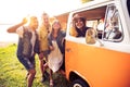 Summer holidays, road trip, vacation, travel and people concept - smiling young hippie friends having fun over minivan Royalty Free Stock Photo