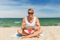 Happy smiling young man with tablet pc on beach Royalty Free Stock Photo