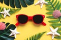 Summer holidays.Top view of red sunglasses, starfish, seashells,monstera leaf and tropical palm leaves. Summer vacation concept Royalty Free Stock Photo