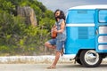 Hippie man playing guitar at minivan car on island Royalty Free Stock Photo