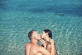 Summer holidays and travel vacation. woman and man swim in sea water. Love relations of kissing couple enjoying Royalty Free Stock Photo