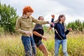 Summer holidays vacation happy people concept. Group of three friends boy and two girls dancing and having fun together outdoors. Royalty Free Stock Photo