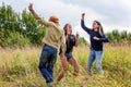 Summer holidays vacation happy people concept. Group of three friends boy and two girls dancing and having fun together outdoors. Royalty Free Stock Photo