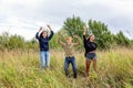 Summer holidays vacation happy people concept. Group of three friends boy and two girls dancing and having fun together outdoors. Royalty Free Stock Photo