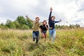 Summer holidays vacation happy people concept. Group of three friends boy and two girls running and having fun together outdoors. Royalty Free Stock Photo