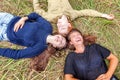 Summer holidays vacation happy people concept. Top view group of three friends lying on grass in circle smiling and having fun Royalty Free Stock Photo
