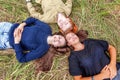 Summer holidays vacation happy people concept. Top view group of three friends lying on grass in circle smiling and having fun Royalty Free Stock Photo