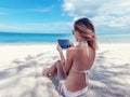 summer holidays, vacation, technology and internet - girl looking at tablet pc on the beach chair Royalty Free Stock Photo