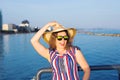 Summer holidays, vacation, travel and people concept - smiling laughing young woman wearing sunglasses and hat on beach Royalty Free Stock Photo