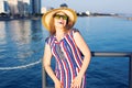 Summer holidays, vacation, travel and people concept - smiling laughing young woman wearing sunglasses and hat on beach Royalty Free Stock Photo