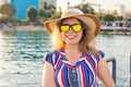 Summer holidays, vacation, travel and people concept - smiling young woman wearing sunglasses and hat on beach over sea Royalty Free Stock Photo