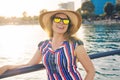 Summer holidays, vacation, travel and people concept - smiling young woman wearing sunglasses and hat on beach over sea Royalty Free Stock Photo