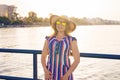 Summer holidays, vacation, travel and people concept - smiling young woman wearing sunglasses and hat on beach over sea Royalty Free Stock Photo