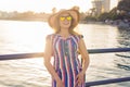 Summer holidays, vacation, travel and people concept - smiling young woman wearing sunglasses and hat on beach over sea Royalty Free Stock Photo