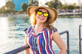 Summer holidays, vacation, travel and people concept - smiling young woman wearing sunglasses and hat on beach over sea Royalty Free Stock Photo