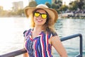 Summer holidays, vacation, travel and people concept - smiling young woman wearing sunglasses and hat on beach over sea Royalty Free Stock Photo