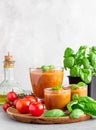 Summer homemade cold tomato cream soup in glass. Traditional Spanish soup gazpacho with basil. Grey concrete background Royalty Free Stock Photo