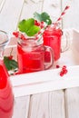 Summer homemade red currant lemonade in mason jar with decor of berry in tray on ligth wooden table. Close up. Royalty Free Stock Photo