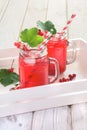 Summer homemade red currant lemonade in a mason jar with decor of berry in tray on rustic table. Close up. Royalty Free Stock Photo