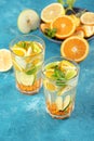 Summer homemade refreshing lemonade with orange, lemon, mint in glasses on blue background Royalty Free Stock Photo