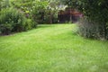 Summer house in the beautiful backyard green garden landscape and fresh, green lawn background.