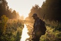 Summer hunting at sunrise. Hunter moving With Shotgun and Looking For Prey.