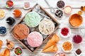 Summer ice cream buffet table with a variety of flavors and sweet toppings. Overhead view on rustic white wood. Royalty Free Stock Photo