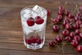 Summer iced drink - cherry with ice. On rustic wooden table Royalty Free Stock Photo