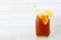 Iced tea in a mason jar glass, side view against white wood Royalty Free Stock Photo